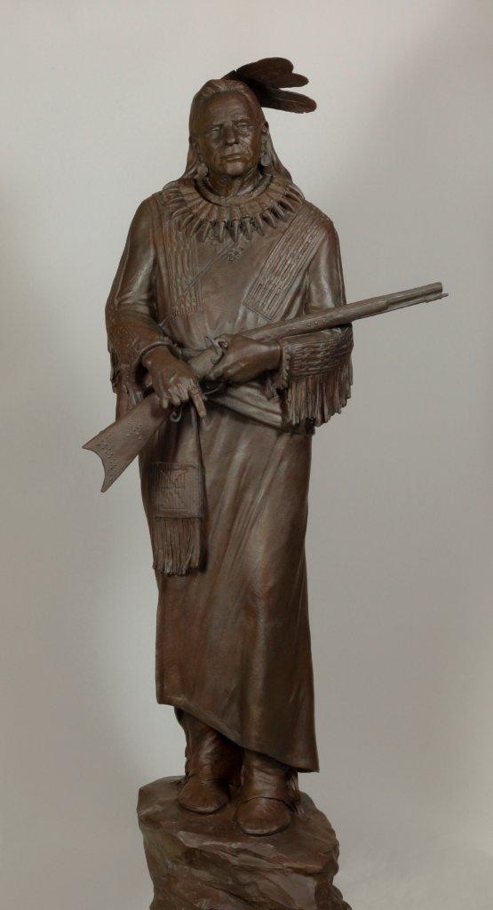 Bronze sculpture of Native American holding rifle by Paul Moore