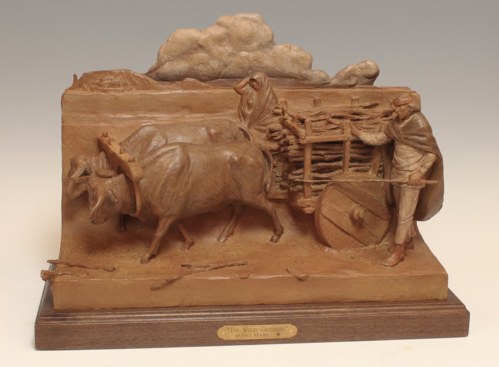 Bronze sculpture of Native American gathering wood on ox cart by Paul Moore
